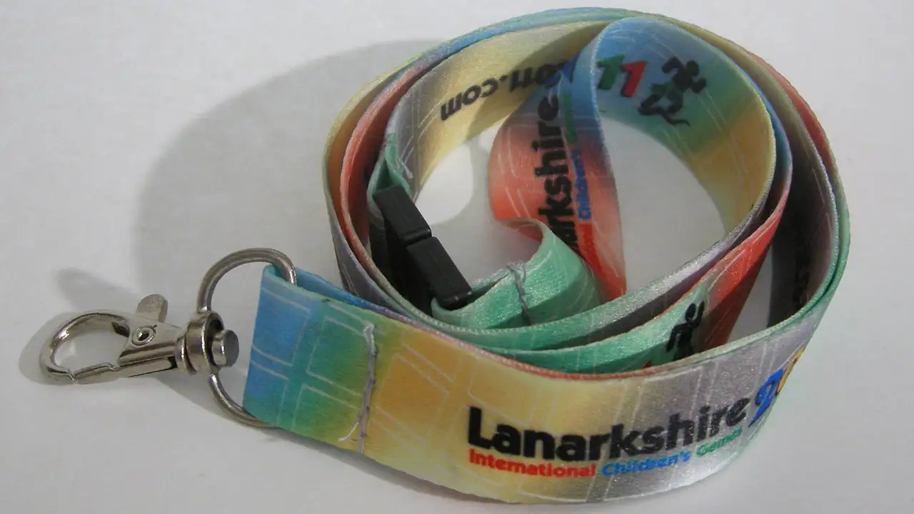 Nyckelband med digitalt tryck som visar hur trycket täcker hela bandet med färgtoningar, text och logotyp.