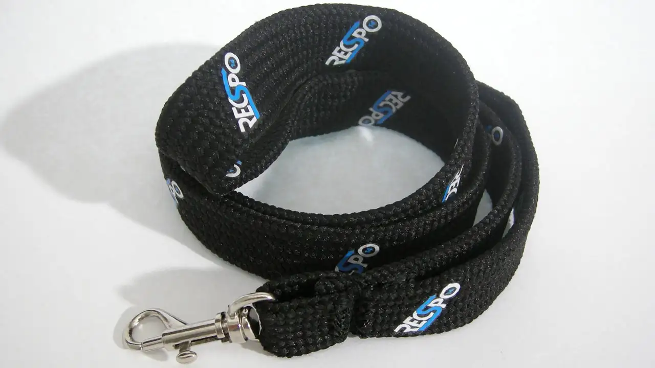 Svart tubvävt nyckelband med rundade kanter och screentryckt blå och vit logotyp.